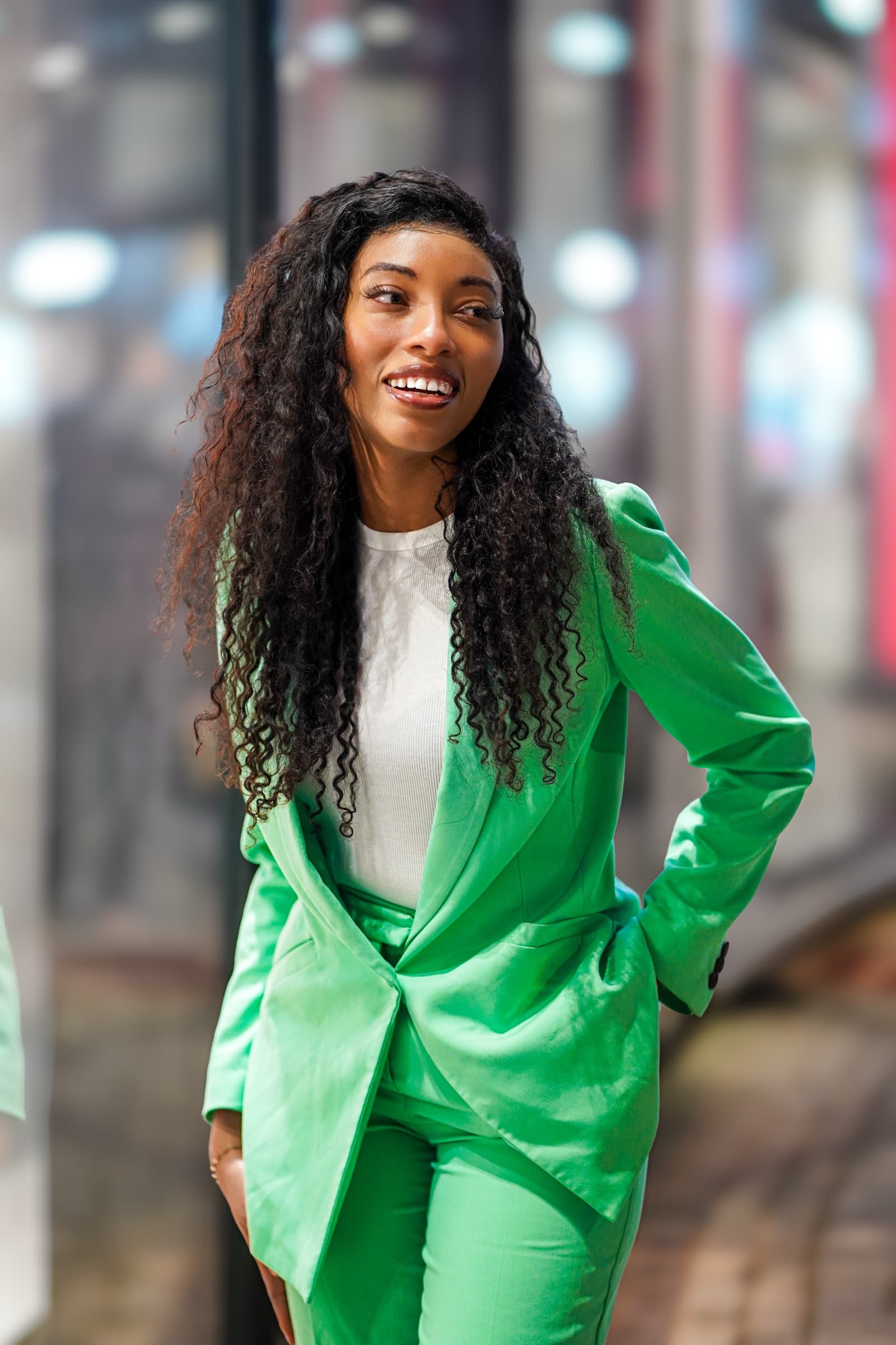 Vibrant green satin suit, urban evening light