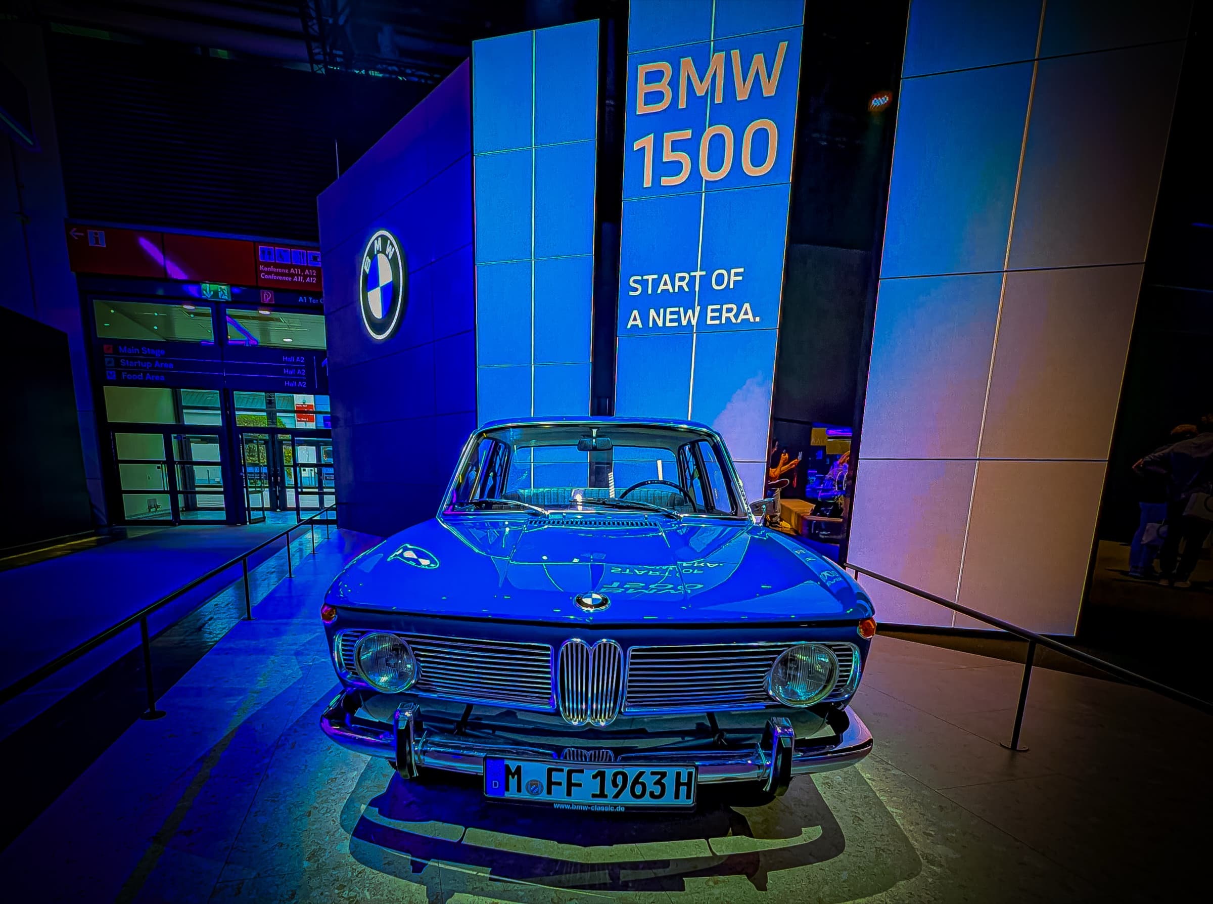 Vintage BMW 1500 in deep blue under spotlight
